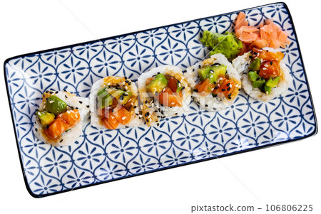 On blue and white plate there is Saketaki roll of crab, avocado, cucumber and salmon 106806225