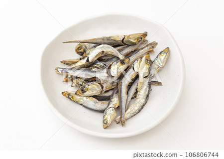 Dried sardines on a white plate, white background Dried sardines on a white plate, white background 106806744