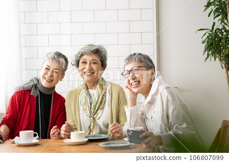 Senior friends having tea at a cafe and senior women having commemorative photos taken Senior friends having tea at a cafe and senior women having commemorative photos taken 106807099