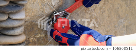 Craftsman installs water faucet on concrete wall close-up. Craftsman installs water faucet on concrete wall close-up. 106808511