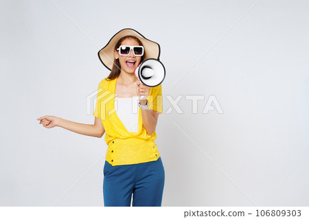 Young woman wearing sun hat, sunglasses and holding megaphone isolated on white background. Lifestyle summer and announce concept. 106809303