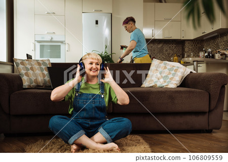 Beautiful elderly woman listening to calm music with headphones Beautiful elderly woman listening to calm music with headphones 106809559