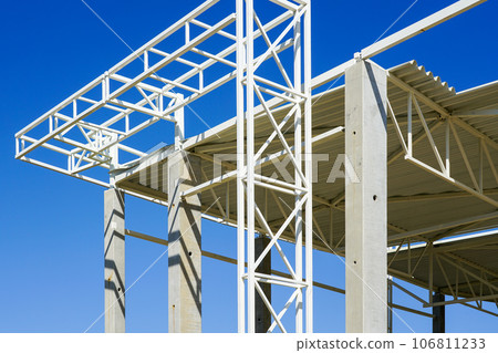 Unfinished commercial building steel and concrete frame facade fragment against a blue sky Unfinished commercial building steel and concrete frame facade fragment against a blue sky 106811233