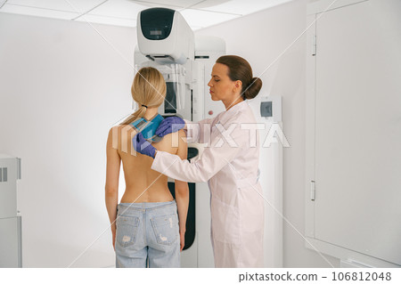 Female doctor prepairing woman before doing mammogram x-ray to check for breast cancer at hospital Female doctor prepairing woman before doing mammogram x-ray to check for breast cancer at hospital 106812048