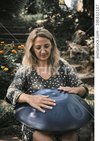 a woman plays on handpan or hang 106812187
