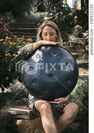 a woman holds a handpan in her hands 106812188