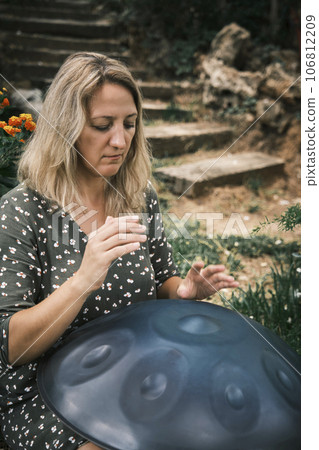 a woman plays on handpan or hang 106812209