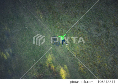 Aerial view of cyclist resting in meadow 106812211
