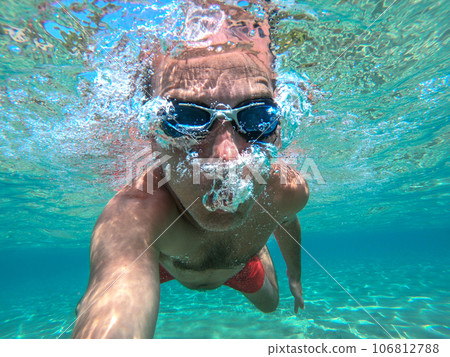 Man swimming underwater 106812788