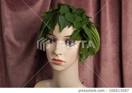 a display mannequin wearing hair of leaves on pink velvet background a display mannequin wearing hair of leaves on pink velvet background 106813087