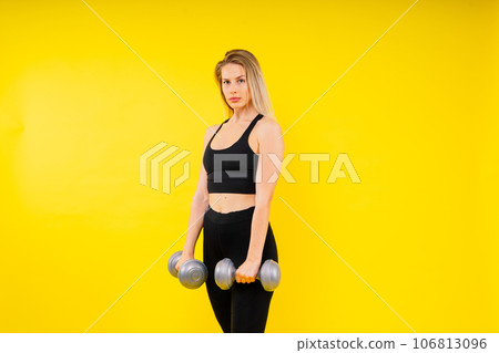 Perfect sporty female working out with dumbbells. Photo of woman in sportswear, studio 106813096