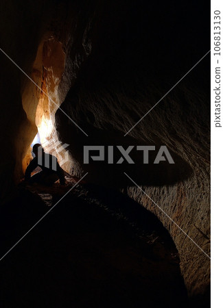 Spelunker exploring a cave Spelunker exploring a cave 106813130