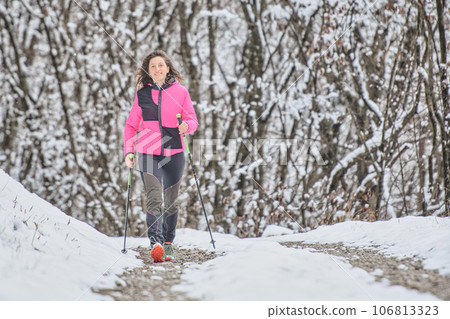 A young woman walks in snowy path 106813323