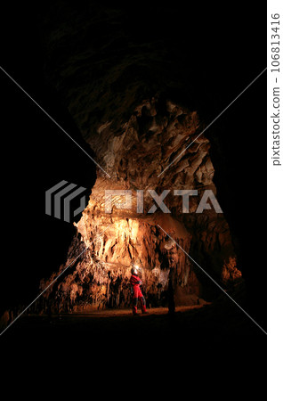 Spelunker wondering in a cave Spelunker wondering in a cave 106813416