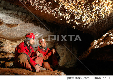 Geologists studying minerals in a cave Geologists studying minerals in a cave 106813594