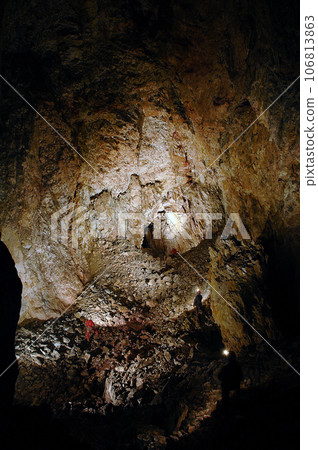 Spelunkers in a gigantic cave hall 106813863