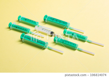 Top view of different syringes at yellow background. Medical injection concept with copy space 106814074