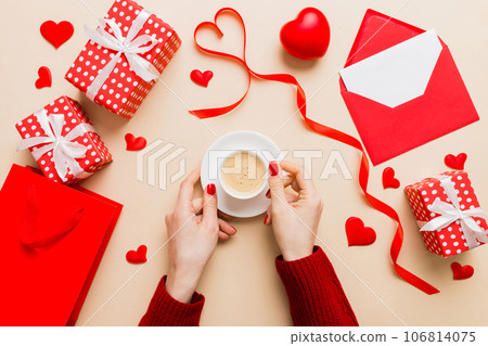 Flat lay of heart shaped cup of black coffee in the hands of women on colored background with copy space top view. Valentine day and holiday concept 106814075