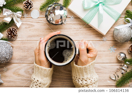 Woman holding cup of coffee. Woman hands holding a mug with hot coffee. Winter and Christmas time concept 106814136