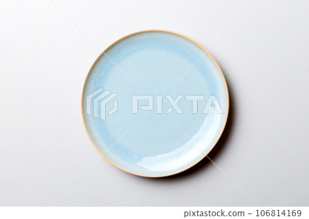 Top view of isolated of colored background empty round blue plate for food. Empty dish with space for your design 106814169