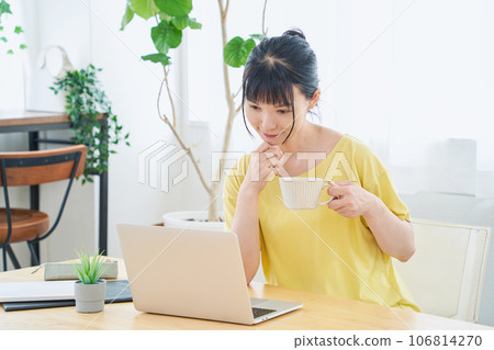 A woman doing telework talking to a monitor A woman doing telework talking to a monitor 106814270