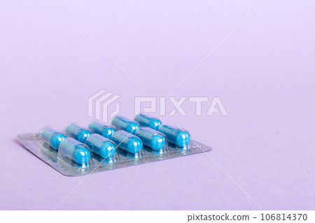 Blister package with Vitamin on color background. Medicine pills on a light background. Medicines and prescription pills flat lay background. blue medical tablets in blister Blister package with Vitamin on color background. Medicine pills on a light background. Medicines and prescription pills flat lay background. blue medical tablets in blister 106814370