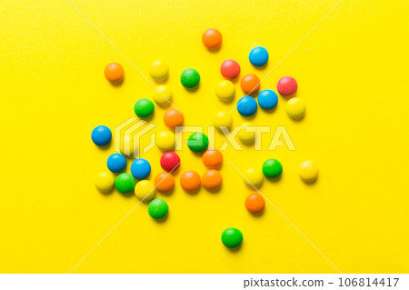 Mixed collection of colorful candy, on colored background. Flat lay, top view. frame of colorful chocolate coated candy 106814417