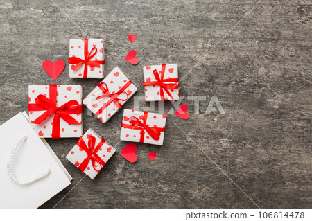 Gift boxes pop out from paper bag top view on colored background. bag packing handmade boxes fall out Concept of holidays, shopping, sale, discounts. Top view, flat lay Gift boxes pop out from paper bag top view on colored background. bag packing handmade boxes fall out Concept of holidays, shopping, sale, discounts. Top view, flat lay 106814478