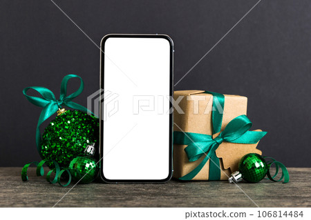 Digital phone mock up with rustic Christmas decorations for app presentation with empty space for you design. Christmas online shopping concept. Tablet with copy space on colored background Digital phone mock up with rustic Christmas decorations for app presentation with empty space for you design. Christmas online shopping concept. Tablet with copy space on colored background 106814484