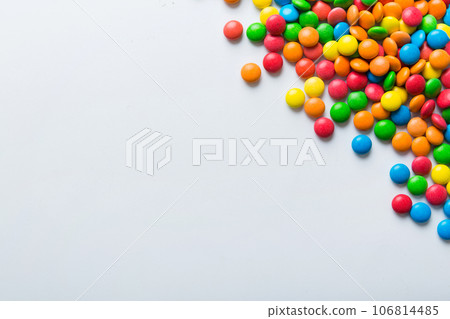 Mixed collection of colorful candy, on colored background. Flat lay, top view. frame of colorful chocolate coated candy Mixed collection of colorful candy, on colored background. Flat lay, top view. frame of colorful chocolate coated candy 106814485