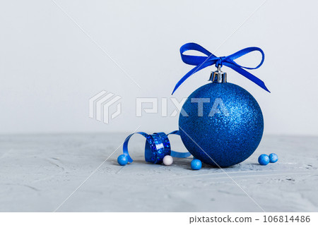 Christmas ball on colored background. decoration bauble with ribbon bow with copy space 106814486