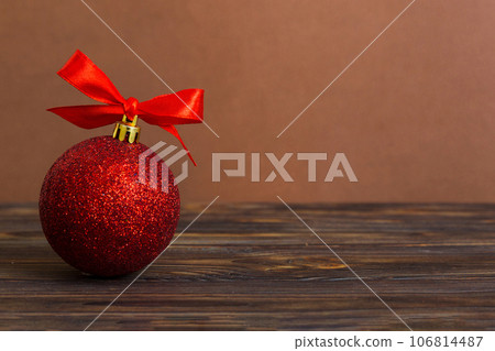 Christmas ball on colored background. decoration bauble with ribbon bow with copy space Christmas ball on colored background. decoration bauble with ribbon bow with copy space 106814487