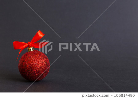 Christmas ball on colored background. decoration bauble with ribbon bow with copy space Christmas ball on colored background. decoration bauble with ribbon bow with copy space 106814490
