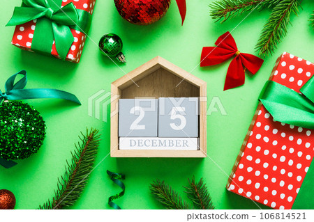 Christmas calendar 25 december. Christmas gift, fir branches, pine cones. Flat lay, top view. New Year decorations on a colored background 106814521