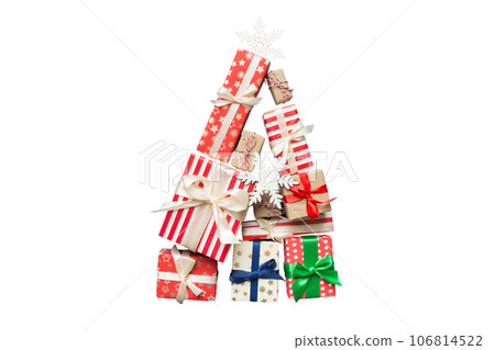 Isolated Christmas tree made of beautifuly wrapped presents on colored background, view from above. New Year gift box minimal concept 106814522