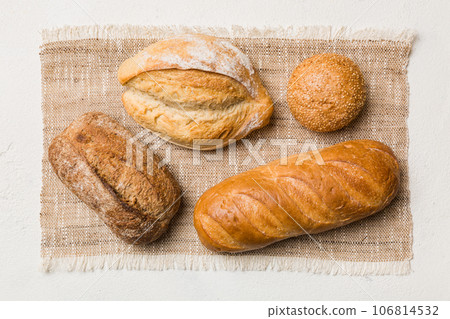 Assortment of freshly baked bread with napkin on rustic table top view. Healthy unleavened bread. French bread 106814532