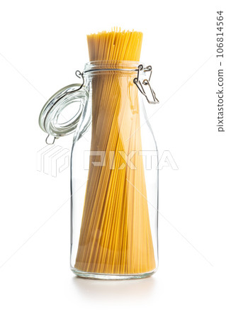 Spaghetti pasta in glass bottle. Uncooked italian pasta isolated on white background. Spaghetti pasta in glass bottle. Uncooked italian pasta isolated on white background. 106814564