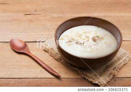 Traditional chinese porridge rice gruel in brown bowl  with wooden spoon 106815371