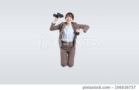 Middle-aged woman jumping with binoculars 106816737