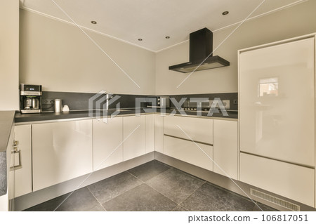 a modern kitchen with white cabinets and black counter tops in an apartment or residential area, taken from the side 106817051