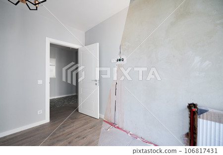Photo collage of apartment room before and after restoration or refurbishment. Old room with doorway and new renovated living room with parquet floor and elegant interior design. 106817431