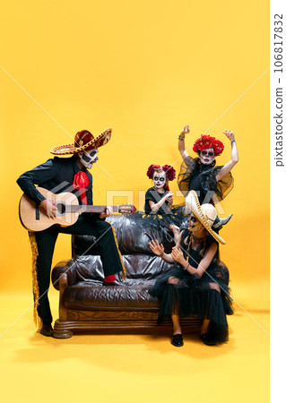 Zombies family. Dancing mother, playing on guitar and singing father with spooky makeup. celebrating halloween. 106817832