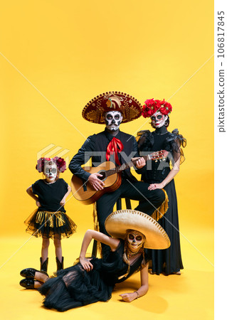 Dead mexican family with sombrero on halloween party. Studio shot of zombies isolated on yellow background. day of the dead. trick or treat 106817845