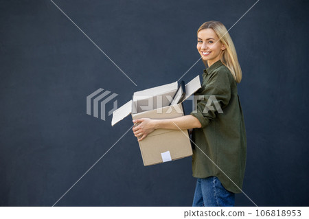 Cute blonde young woman carrying boxes in hands 106818953