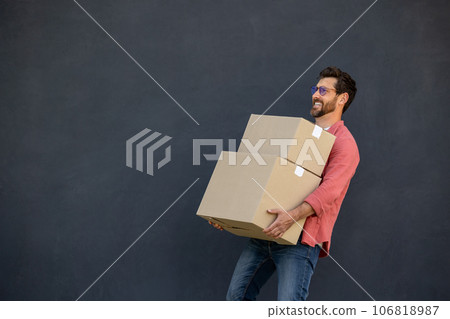 Contented young man with heavy carton boxes in hands 106818987