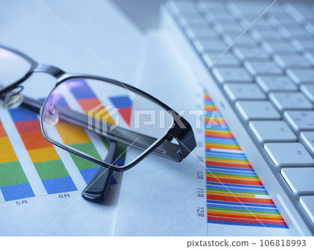 Graphs, keyboard and glasses on the table 106818993