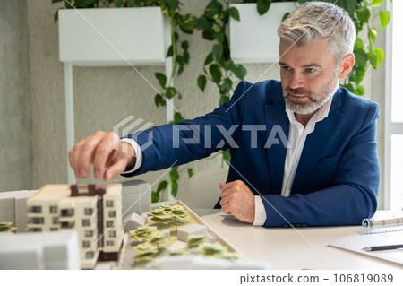 Architect or engineer working with house model in the office. 106819089
