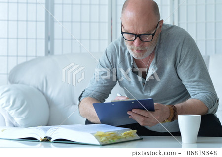 senior old man with book working at home 106819348