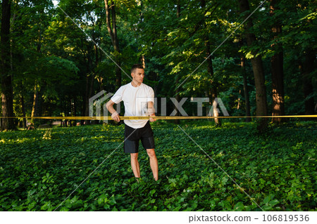 Young man in white tshirt walking on the rope 106819536