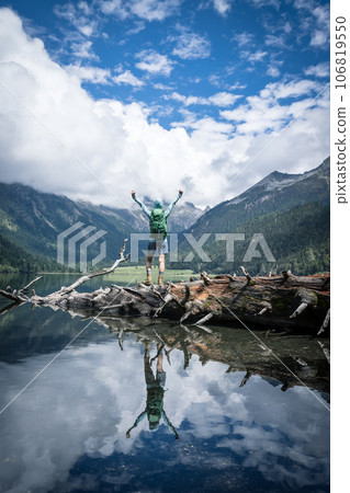 Woman traveller open arms to foggy high altitude mountains Woman traveller open arms to foggy high altitude mountains 106819550